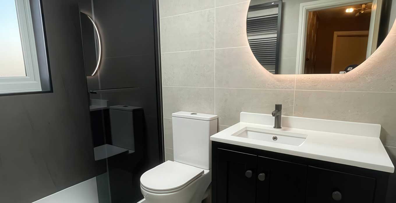 Completed modern bathroom with dark cabinetry and walk-in shower